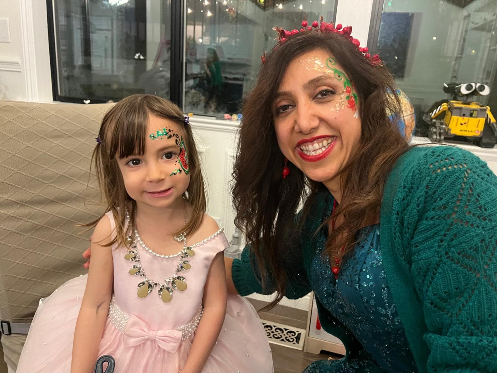 Flower face painting on a girl in a pink dress at a birthday party