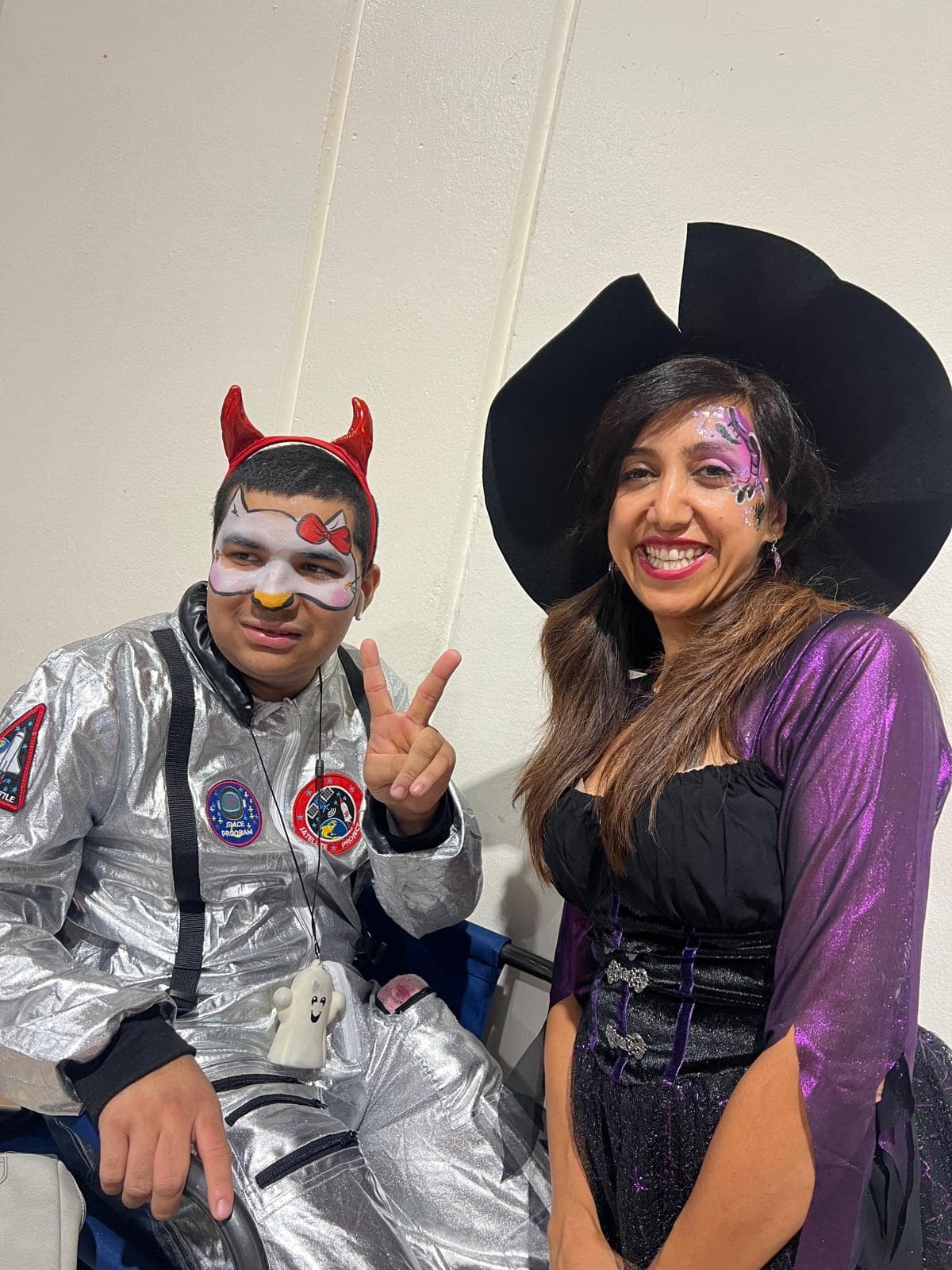 Halloween face painting with devil and witch designs at a costume party